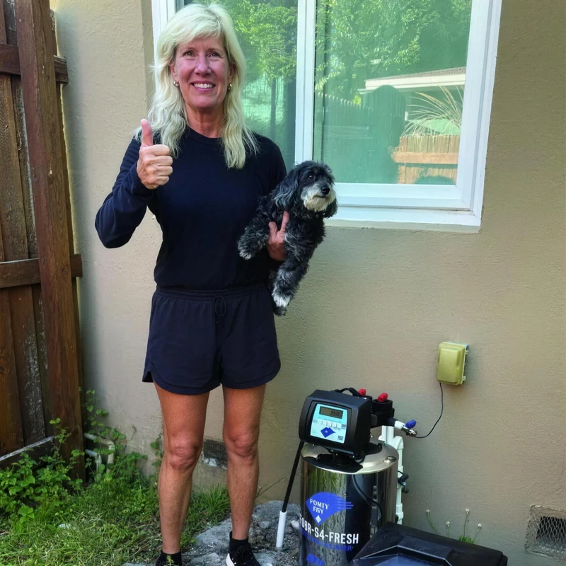 Homeowner with her dog next to her new Purity Bay drinking water system